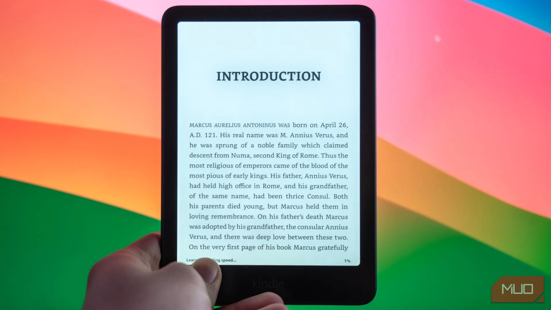 Thiết bị Amazon Kindle Paperwhite Signature Edition trên bàn, cạnh màn hình máy tính hiển thị nội dung đọc sách điện tử.