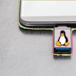 USB cứu hộ SystemRescue với logo Linux Tux gắn vào laptop